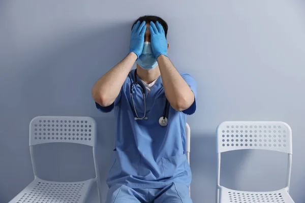 Erschöpfter Arzt Sitzt Auf Stuhl Neben Grauer Wand Krankenhaus — Stockfoto