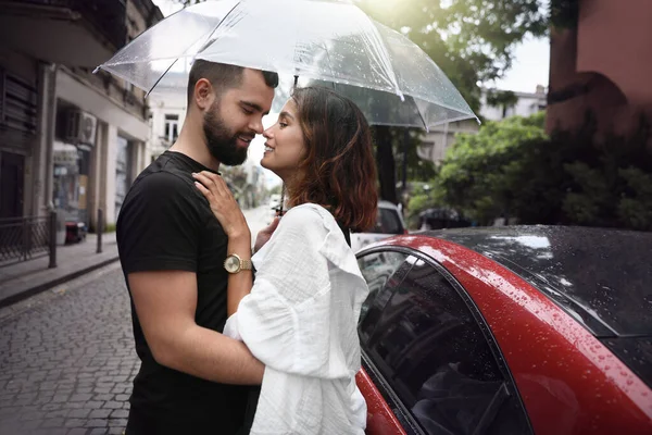 年轻夫妇带着雨伞 在城市街道上的雨中享受着在一起的时光 — 图库照片