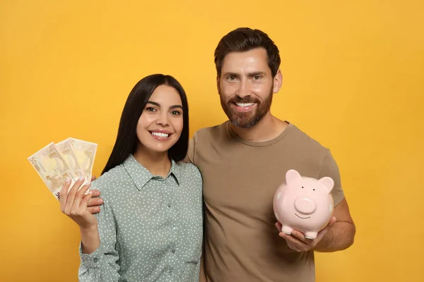 Pareja Feliz Con Alcancía Cerámica Dinero Sobre Fondo Naranja — Foto de Stock