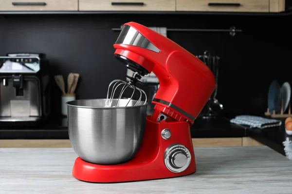 Modern stand mixer on wooden table in kitchen. Home appliance