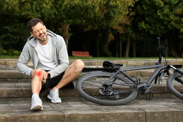 Muž Zraněným Kolenem Schodech Blízkosti Kola Venku — Stock fotografie