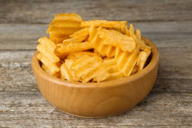 Tahta masada lezzetli patates cipsli kase, yakın plan.