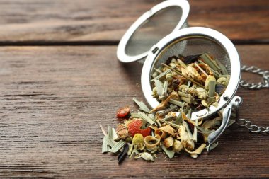 Kurutulmuş bitki çayı yapraklarıyla ahşap masaya yakın çekim yap. Metin için boşluk