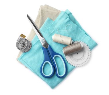 Beyaz arkaplanda makas, iplik makaraları ve dikiş araçları, üst görünüm