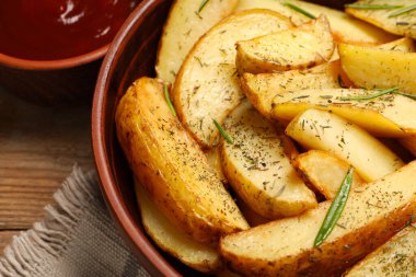 Ahşap masada baharatlı lezzetli fırında patatesler, yakın plan.