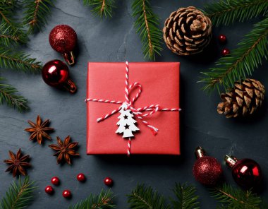 Güzel hediye kutusu ve koyu arkaplanda farklı bir Noel dekoru olan düz bir kompozisyon.