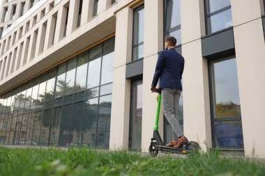 Şehir caddesinde, arka planda modern scooter kullanan bir iş adamı. Metin için boşluk