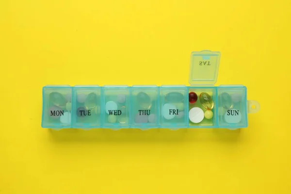 Пластиковая Коробка Различными Таблетками Желтом Фоне Вид Сверху — стоковое фото