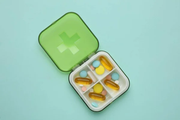 Caja Plástico Con Diferentes Píldoras Sobre Fondo Azul Claro Vista —  Fotos de Stock