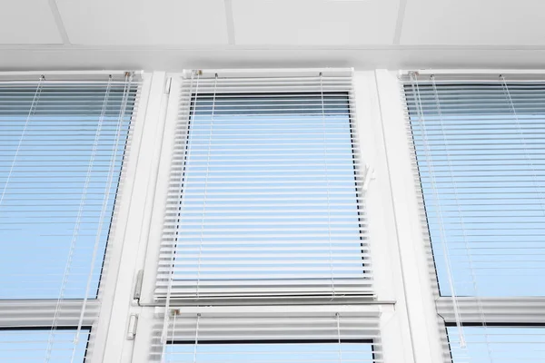 Large window with horizontal blinds indoors, low angle view