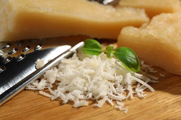 Geriebener Parmesan Mit Basilikum Neben Reibe Auf Holztisch Nahaufnahme — Stockfoto