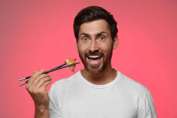 Emotional Man Holding Tasty Sushi Chopsticks Pink Background — Stock Photo, Image