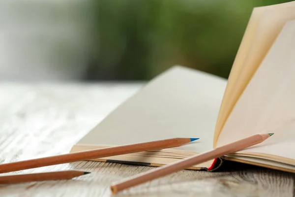 Closeup View Open Notebook Pencils White Wooden Table Blurred Background — Stock fotografie