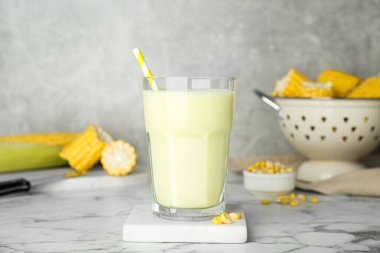 Beyaz mermer masada cam içinde lezzetli taze mısır sütü.