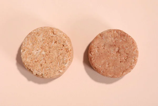 Solid shampoo bars on pink background, flat lay. Hair care