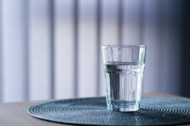 Ahşap masada bulanık arka planda bir bardak su. Metin için boşluk