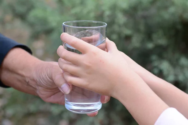 Criança Dando Copo Água Para Mulher Idosa Livre Close — Fotografia de Stock