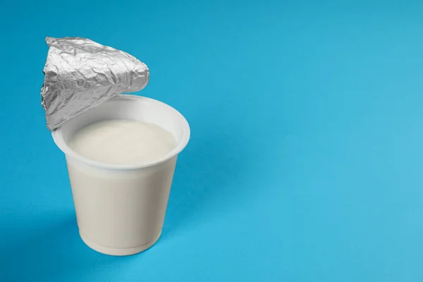 Copa Plástico Con Sabroso Yogur Sobre Fondo Azul Claro Espacio — Foto de Stock