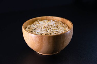 Siyah arka planda bir kasede yulaf ezmesi