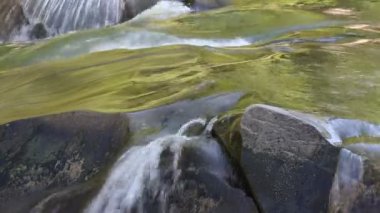 Rough current of a mountain river and stones. Video of beautiful water movement in the wild. Freshness of nature. Wildlife photography for background