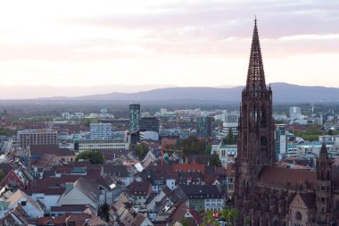 Freiburg şehri, Almanya - 20 Eylül 2022: Eski şehrin güzel manzarası. Eski şehrin güzel manzarası. Çatı ve katedral. Yüksek kule. Gökyüzünde yaz günbatımı