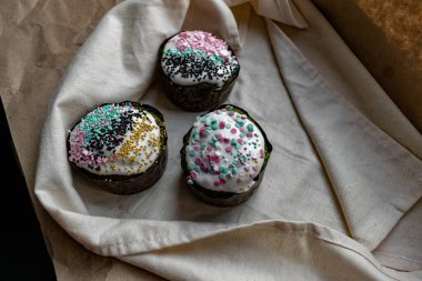 Paskalya Bayramı ev yapımı Paskalya pastaları, üzerine beyaz eggnog kreması serpiştirilmiş renkli Paskalya pastaları, Paskalya bayramı için tatlı geleneksel pastalar, Ortodoks un yemeğinin süslemeleri.