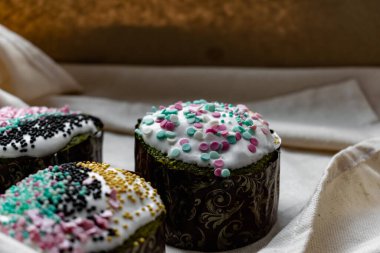 Paskalya Bayramı ev yapımı Paskalya pastaları, üzerine beyaz eggnog kreması serpiştirilmiş renkli Paskalya pastaları, Paskalya bayramı için tatlı geleneksel pastalar, Ortodoks un yemeğinin süslemeleri.