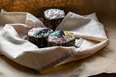 Paskalya Bayramı ev yapımı Paskalya pastaları, üzerine beyaz eggnog kreması serpiştirilmiş renkli Paskalya pastaları, Paskalya bayramı için tatlı geleneksel pastalar, Ortodoks un yemeğinin süslemeleri.