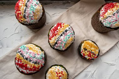 Paskalya Bayramı ev yapımı Paskalya pastaları, üzerine beyaz eggnog kreması serpiştirilmiş renkli Paskalya pastaları, Paskalya bayramı için tatlı geleneksel pastalar, Ortodoks un yemeğinin süslemeleri.