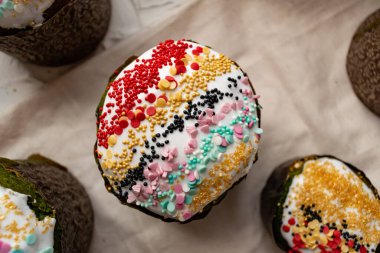 Paskalya Bayramı ev yapımı Paskalya pastaları, üzerine beyaz eggnog kreması serpiştirilmiş renkli Paskalya pastaları, Paskalya bayramı için tatlı geleneksel pastalar, Ortodoks un yemeğinin süslemeleri.