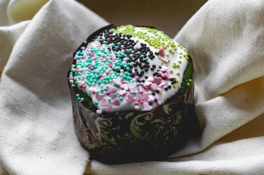 Paskalya Bayramı ev yapımı Paskalya pastaları, üzerine beyaz eggnog kreması serpiştirilmiş renkli Paskalya pastaları, Paskalya bayramı için tatlı geleneksel pastalar, Ortodoks un yemeğinin süslemeleri.