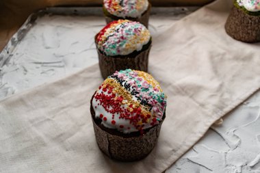 Paskalya Bayramı ev yapımı Paskalya pastaları, üzerine beyaz eggnog kreması serpiştirilmiş renkli Paskalya pastaları, Paskalya bayramı için tatlı geleneksel pastalar, Ortodoks un yemeğinin süslemeleri.