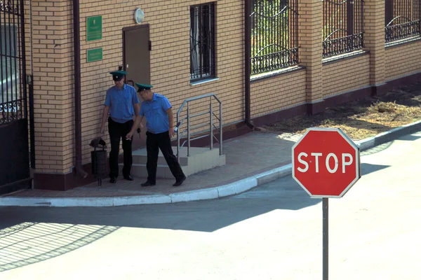 Таможенники курят на фоне дорожного знака "Стоп" — стоковое фото