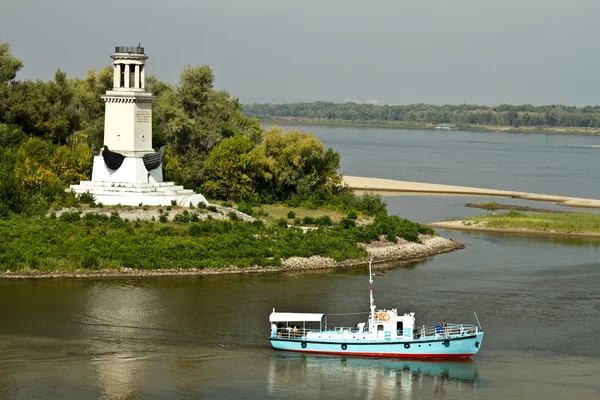Trading barge sailing along the river past the lighthouse — Stock Photo, Image