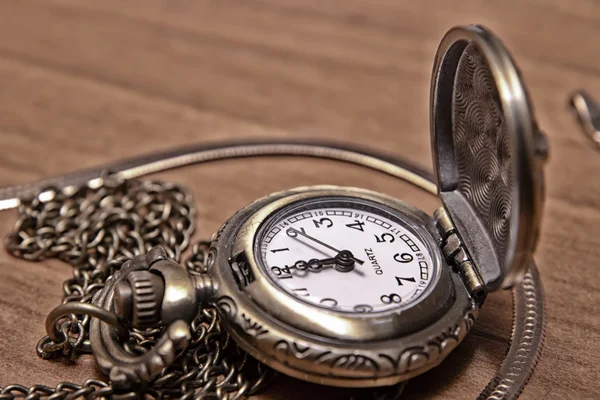 木製の机の背景にポケット時計チェーン — ストック写真