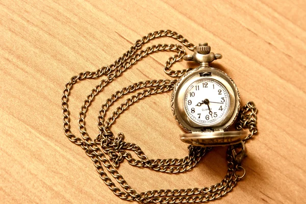 Cadena de reloj de bolsillo en el fondo de un escritorio de madera — Foto de Stock