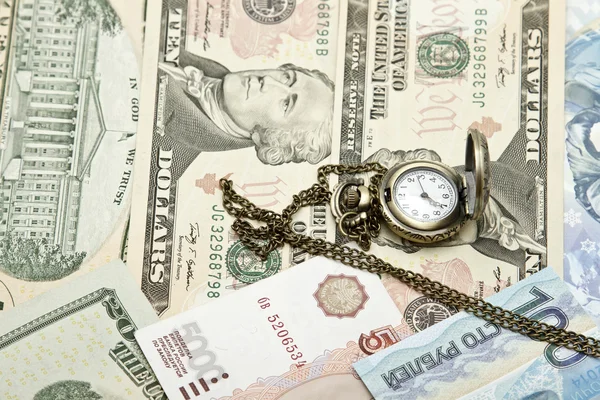 Kapesní hodinky lež na dolary — Stock fotografie