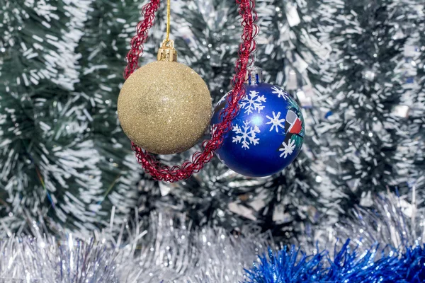 Two Christmas tree bulb hanging on a background of new year's tinsel — Stock Photo, Image