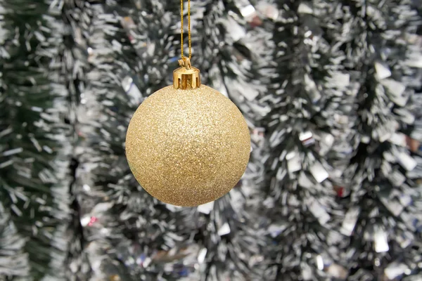 The Golden ball against the background of new year's tinsel — Stock Photo, Image