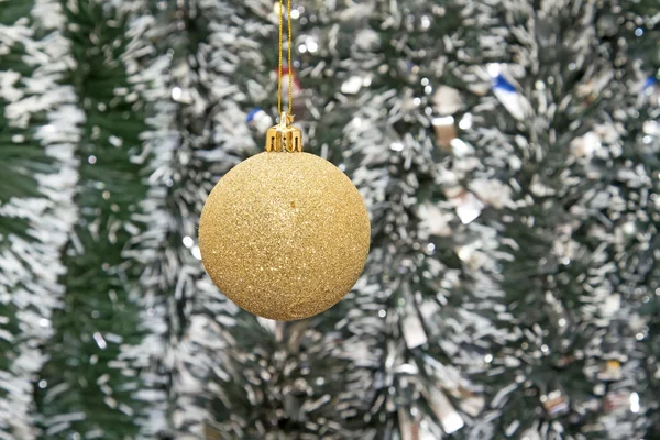 The Golden ball against the background of new year's tinsel — Stock Photo, Image