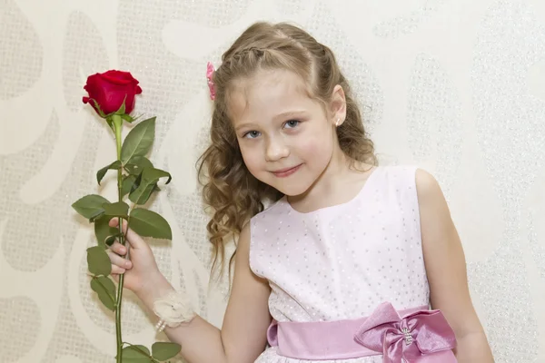 Malá holčička v šatech drží růži — Stock fotografie