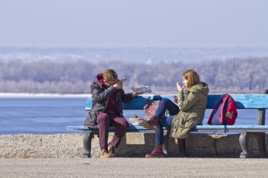 genç bir çift bir bankta kruvasan yemek bir güneşli bir bahar günü aşk