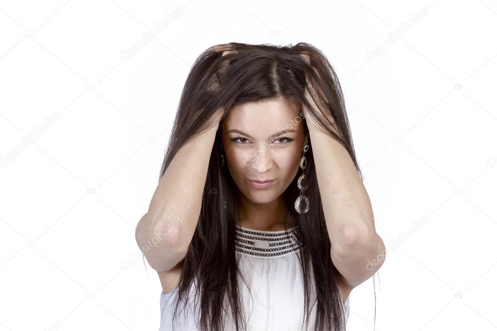 Young beautiful girl emotionally clutching her head hair raising