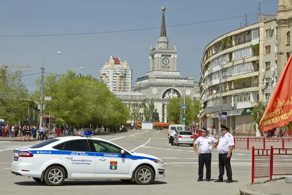 Nuova auto della polizia e la polizia sono in piedi nel cordone alla parata della vittoria vicino alla stazione ferroviaria centrale Volgograd-1  . — Foto Stock