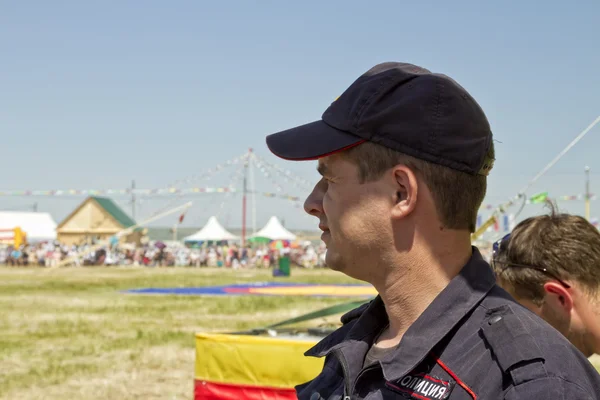 Een politieman in een baseballcap ziet er zorgvuldig in de verte — Stockfoto