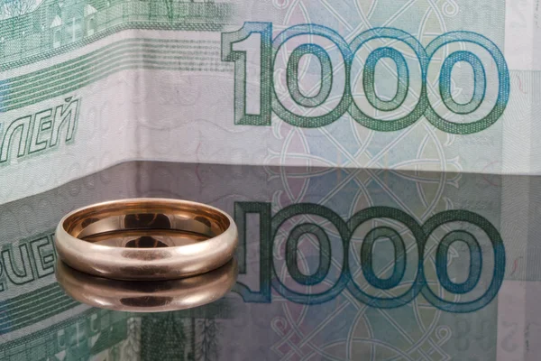 Bague de mariage en or sur le fond de billets de banque mille roubles — Photo