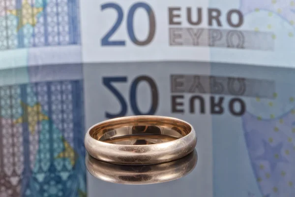 Gold ring on background of Euro banknotes with reflection — Stock Photo, Image