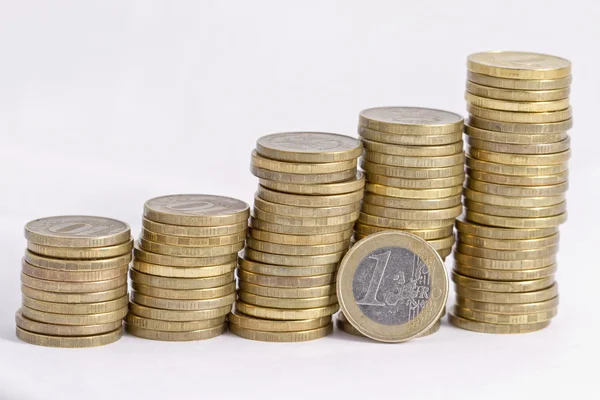 Pila de monedas de oro y moneda 1 euro — Foto de Stock
