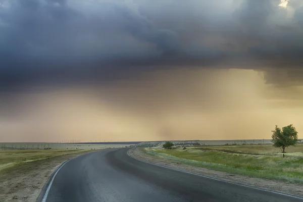 Camino de asfalto se disparó bajo un cielo tormentoso —  Fotos de Stock