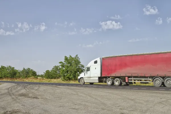 A truck with a red trailer goes on the road — Stock Photo, Image